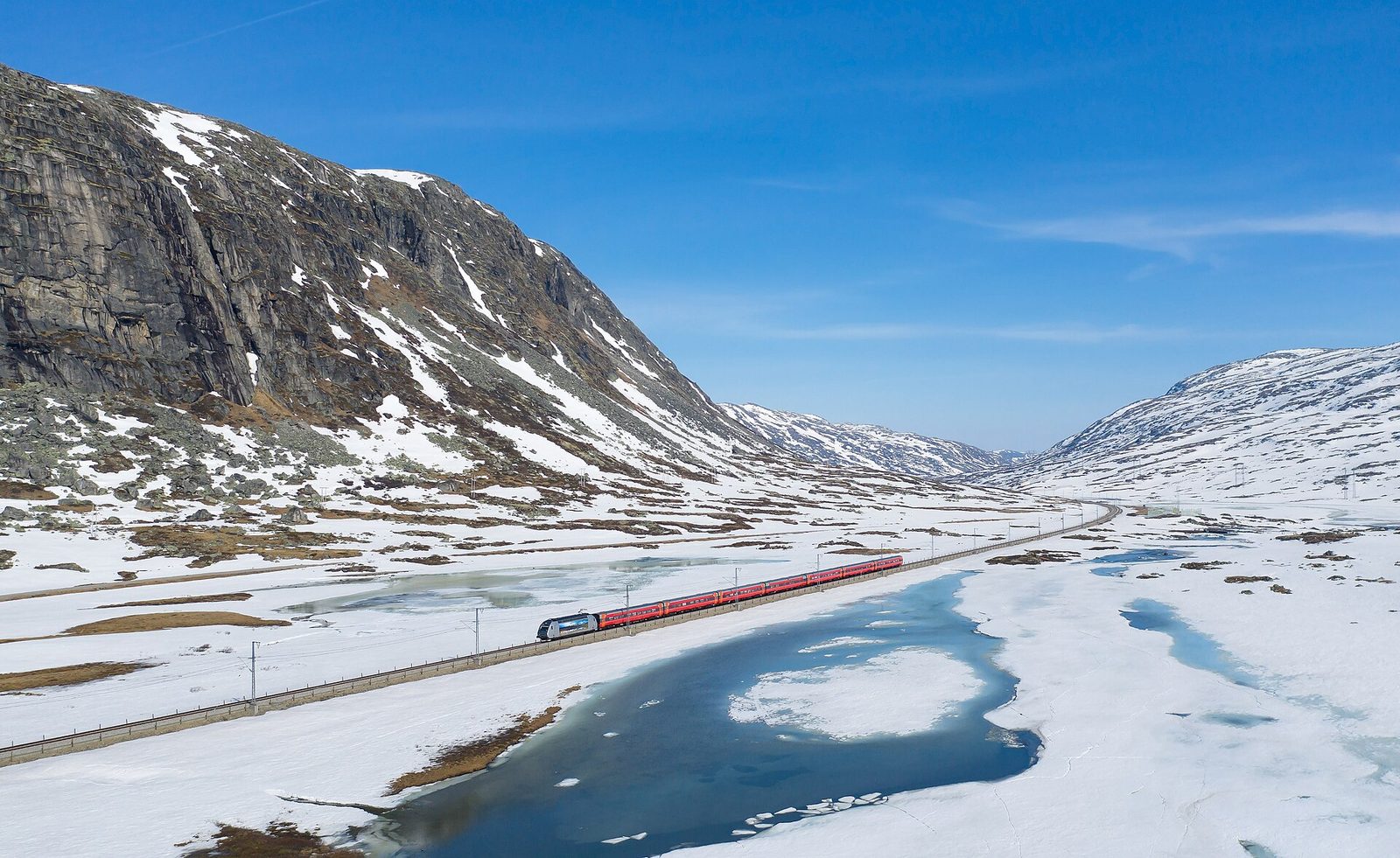 A Vy train on the Bergen Line in the mountains — getting around Norway by rail