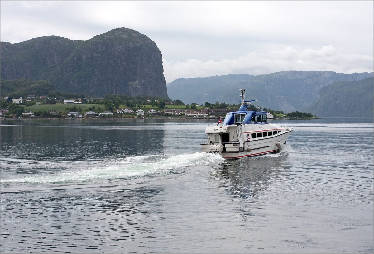 Sightseeing boat cruising the steep granite walls of the Lysefjord from Stavanger