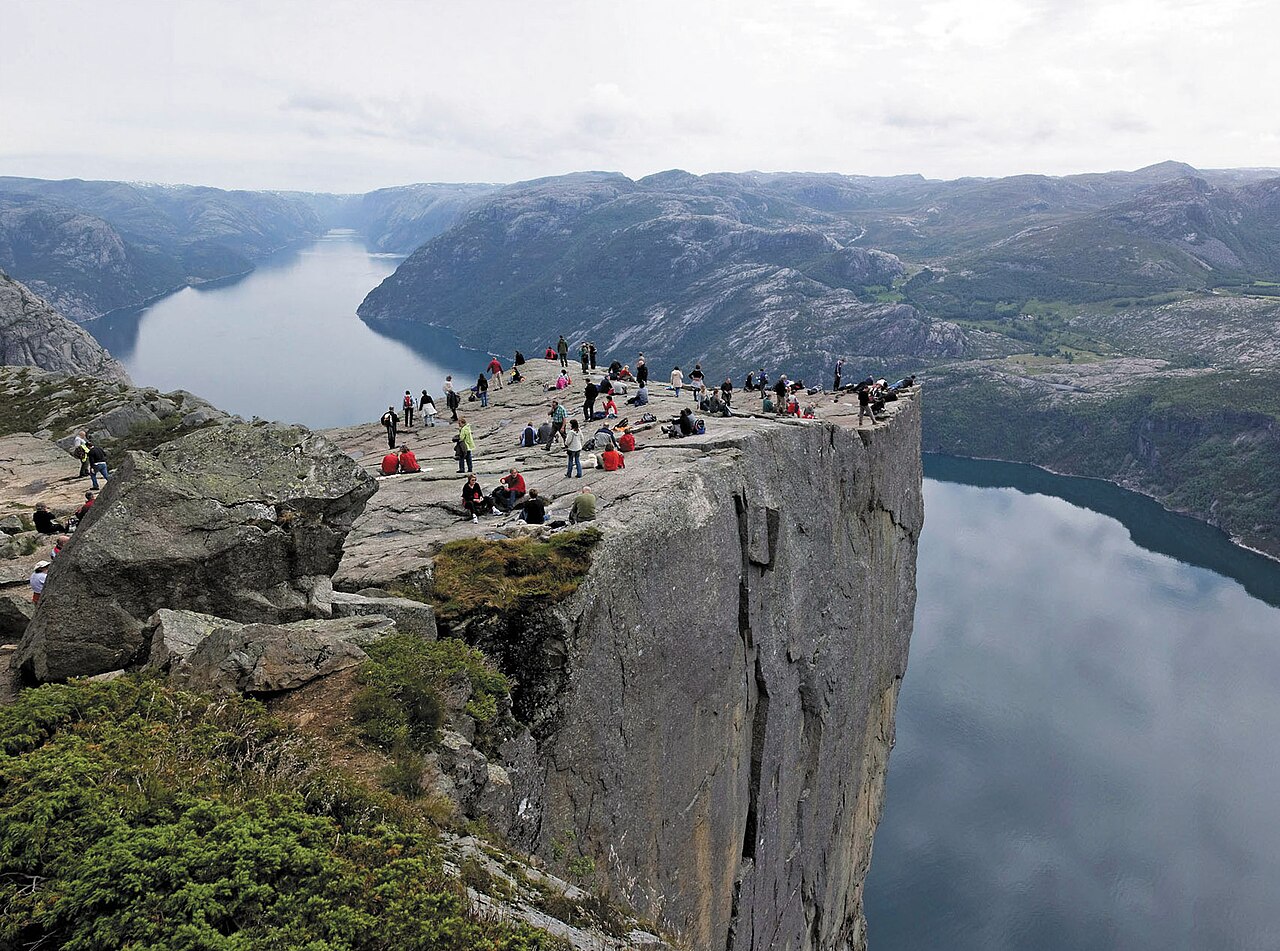 Hikers on the flat granite plateau of Preikestolen (Pulpit Rock), 604 metres above the Lysefjord
