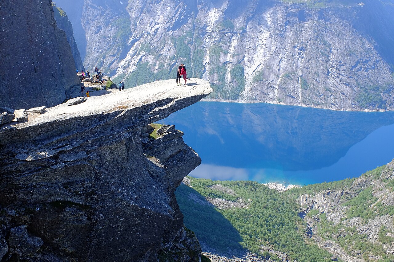 Hikers on the Trolltunga rock ledge above Ringedalsvatnet — the most famous hiking in Norway photo spot
