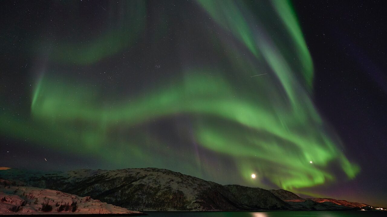 Green northern lights over the Arctic coast near Tromsø, the top entry on any Norway bucket list