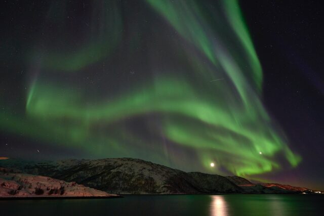 Green northern lights over the Arctic coast near Tromsø, the top entry on any Norway bucket list